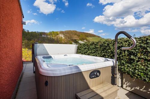 a jacuzzi tub on a balcony with a view at Ramada by Wyndham Baden Hotel du Parc in Baden