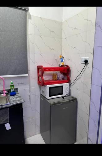 a kitchen with a microwave on top of a refrigerator at 1Bedroom flat at Magnanimous Apartments Ogudu in Lagos