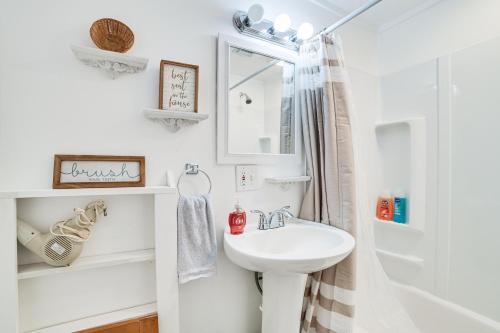 Un baño blanco con lavabo y ducha. en 16 Mi to Clear Lake State Park Secluded Cabin, en Atlanta