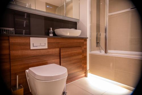a bathroom with a white toilet and a sink at Stylish Kent apartment in Maidstone