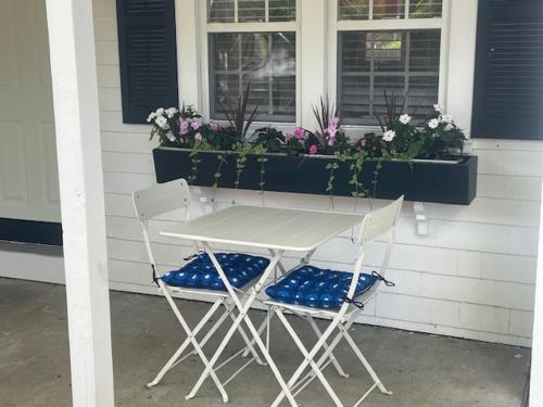2 Stühle und ein Tisch vor einem Haus in der Unterkunft Cape Cod Motor Inn in South Yarmouth