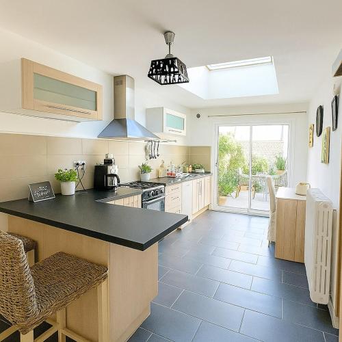 une cuisine avec un comptoir noir dans une pièce dans l'établissement Élégante maison de charme 5 chambres et jardin, à Angers