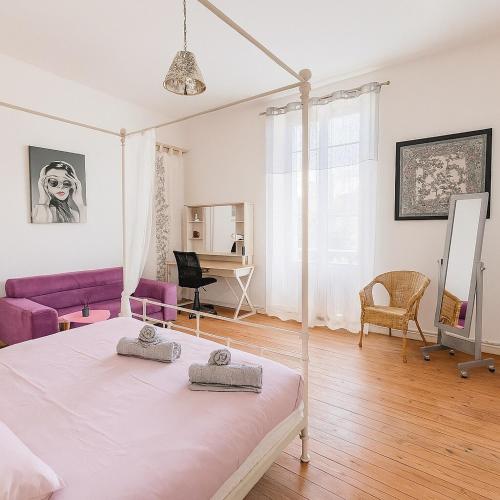 アンジェにあるÉlégante maison de charme 5 chambres et jardinの白いベッドルーム(ベッド1台、紫色のソファ付)