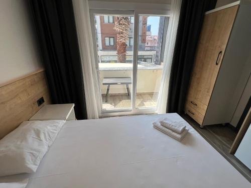 a bedroom with a white bed and a large window at Ada Park Hotel in Kusadası