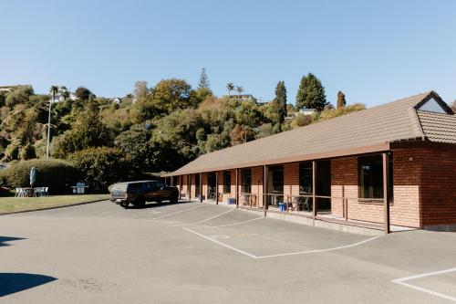 a brick building with a car parked in a parking lot at Amber Court Motel Nelson in Nelson
