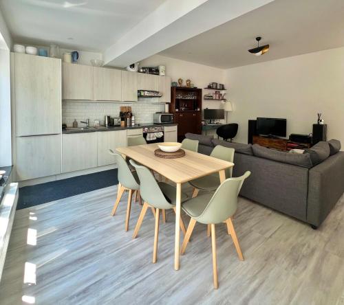 a kitchen and living room with a wooden table and chairs at Tiny House avec terrasse privée, 10 mins du centre in Brussels