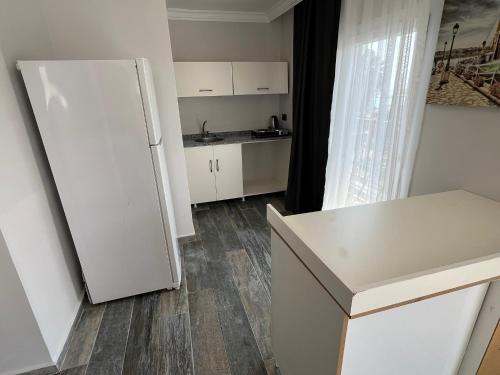 a kitchen with a white refrigerator in a room at Ada Park Hotel in Kusadası