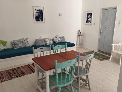 a living room with a table and chairs and a couch at White Cat in Vromolithos