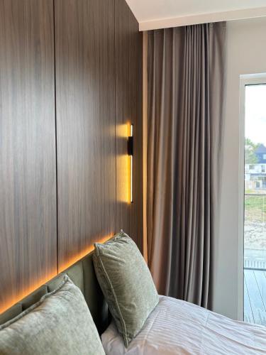 a bedroom with a bed with a wooden headboard at Czarna Perła Hel in Hel
