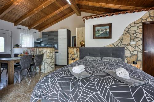 a bedroom with a large bed with a stone wall at Romantic Studio Apartment with Private Pool in Kanfanar