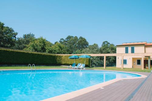 a swimming pool in front of a house at Just Like Home - Casa dos Pinheiros in Caminha