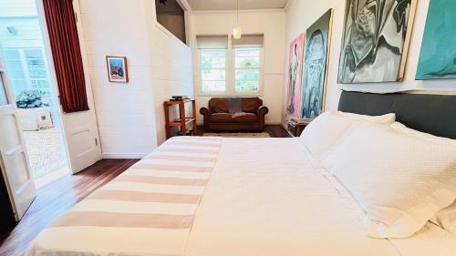 a bedroom with a large white bed and a chair at Casa Botánica de Aranjuez in San José