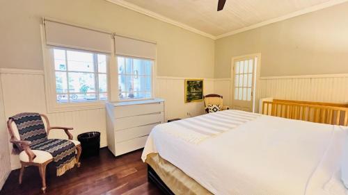 a bedroom with a large bed and two chairs at Casa Botánica de Aranjuez in San José