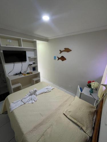 a bedroom with a bed and a tv in a room at Pousada Solmar in Japaratinga