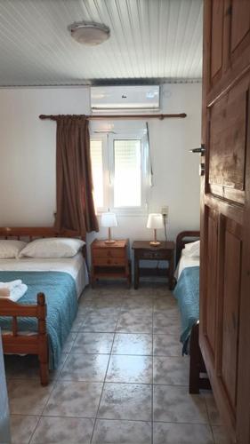 a bedroom with two beds and a window at Azure Horizon in Mochlos