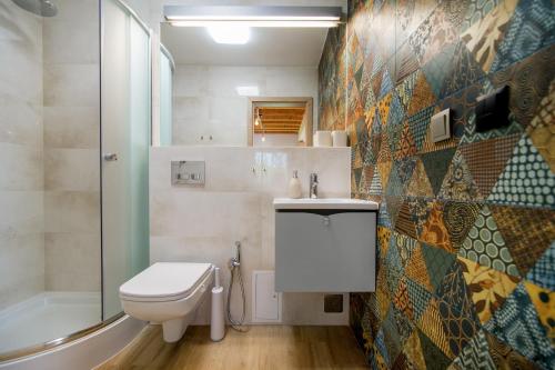 a bathroom with a toilet and a sink and a shower at Domek Bajkowy Zakątek nad jeziorem Narie in Bogaczewo