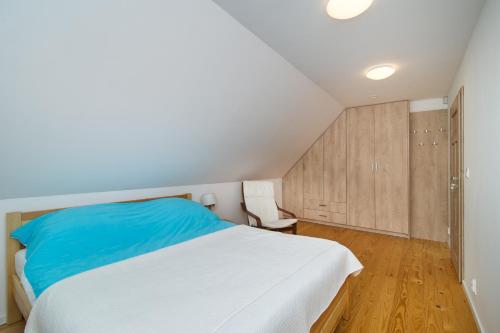 a bedroom with a white bed and wooden cabinets at Domek Bajkowy Zakątek nad jeziorem Narie in Bogaczewo