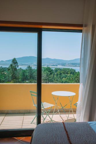a view of a balcony with a table and chairs at Just Like Home - Casa dos Pinheiros in Caminha