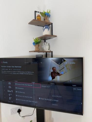 a flat screen tv sitting on top of a desk at 'The Luxury Snug' - A Charming Modern Luxury 2-Bed Flat with Parkview - Free Parking in Northampton