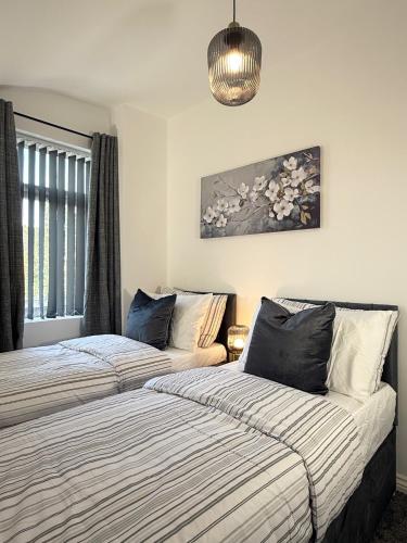 two beds sitting next to each other in a bedroom at 'The Luxury Snug' - A Charming Modern Luxury 2-Bed Flat with Parkview - Free Parking in Northampton
