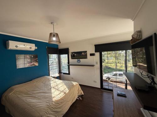 a bedroom with a bed and a blue wall at Quinta en City Bell in City Bell