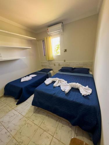 two beds in a room with towels on them at Pousada Solmar in Japaratinga
