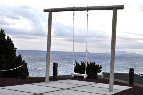 a swing with the ocean in the background at AJITO in Oshima