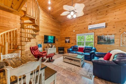 a living room filled with furniture and a tv at Serenity Escape Treehouse on 14 acres near Little River Canyon in Fort Payne