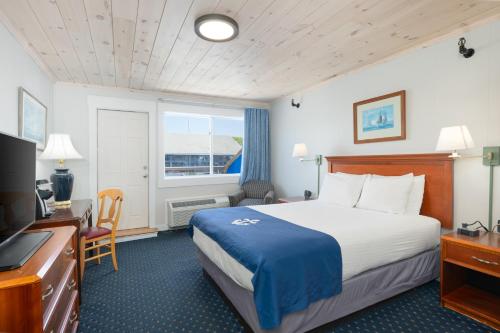 a hotel room with a bed and a television at Fisherman's Wharf Inn in Boothbay Harbor