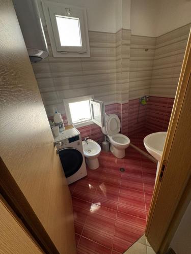 a small bathroom with a toilet and a sink at Paradise Apartment Radhime in Radhimë