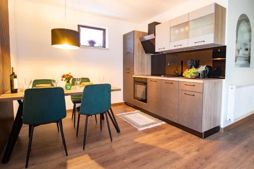 a kitchen and dining room with a table and chairs at Guest House ANA in Otočac