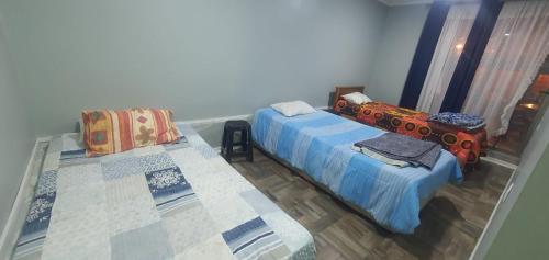 a room with two beds and a window at Casas El Canelo in Isla Negra