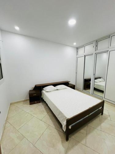 a bedroom with a bed in a white room at MNAKAA BEACH Salkata1 in Sidi Bou Jobline