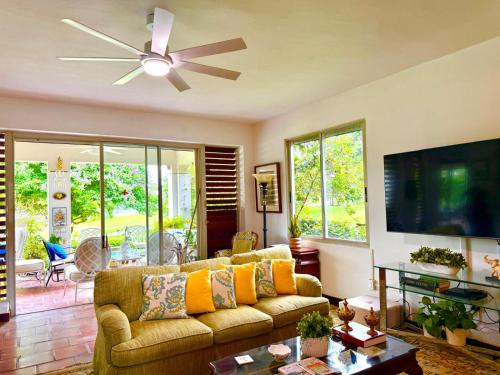 a living room with a couch and a ceiling fan at Villa Teale Serene Dorado Escape in Dorado