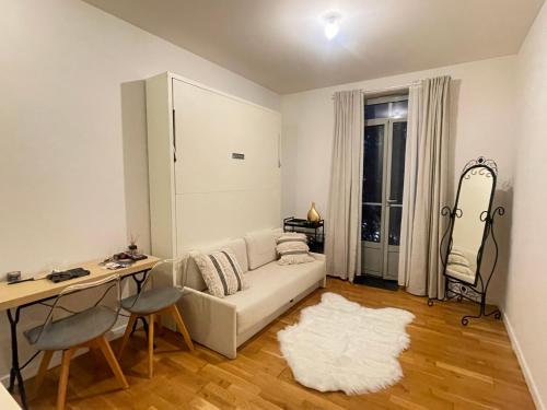 een woonkamer met een witte bank en een tafel bij Studio Carabacel in Nice