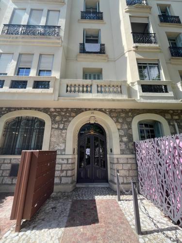 een groot wit gebouw met een houten deur bij Studio Carabacel in Nice