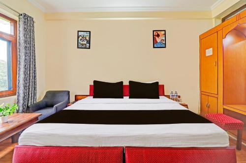 a bedroom with a large bed and a blue couch at Super Collection O Pioneer in Mussoorie