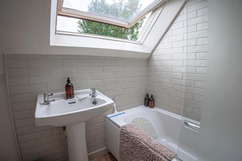 une salle de bains avec lavabo et baignoire dans l'établissement Dreamy Suffolk Country Cottage Escape, à Aldeby