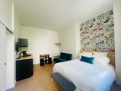 a bedroom with a large white bed and a chair at Studio Calme Coeur Historique in Tours