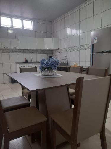 a kitchen with a table with a vase of flowers on it at Casa Dondoca 3 - City of Goiás in Goiás