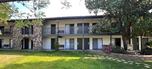 an exterior view of a building with a yard at Lamp Liter Inn in Visalia