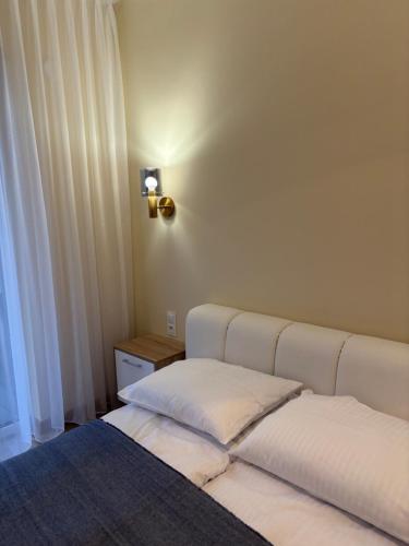 a bedroom with two beds and a lamp on the wall at Czarna Perła Hel in Hel