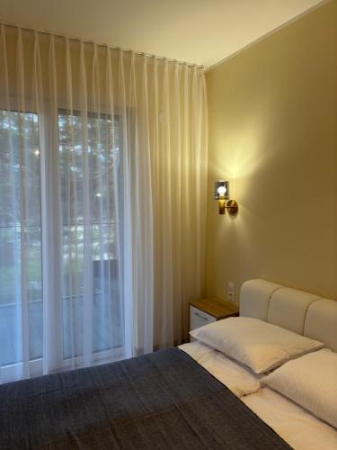 a bedroom with a bed and a large window at Czarna Perła Hel in Hel