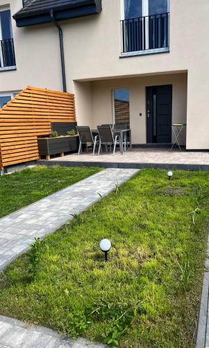 a house with a patio and a grass yard at Apartament M-Sign w Mielenku - 400m od morza! in Mielenko