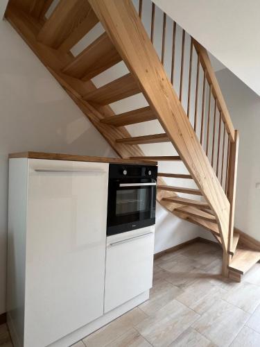 a kitchen with a microwave and a staircase at Apartament M-Sign w Mielenku - 400m od morza! in Mielenko