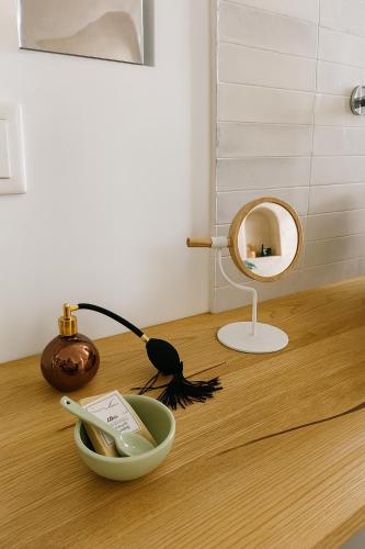 a mirror and a bowl on a wooden table at Arcu Retreat in Positano