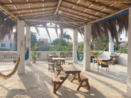 a patio with tables and chairs and hammocks at Pangora, habitación privada de Flor de Lis Beach House in Playas