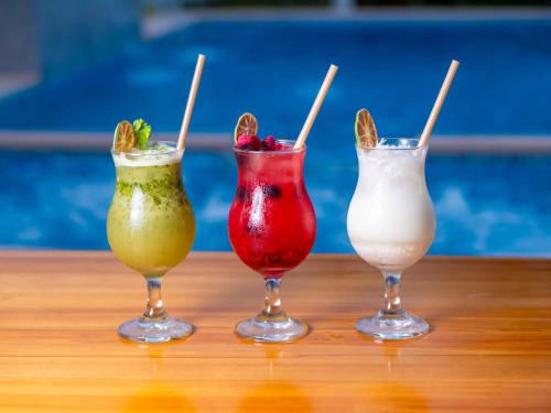 three different colored drinks sitting on a table at Hotel La Mar Playas in Playas