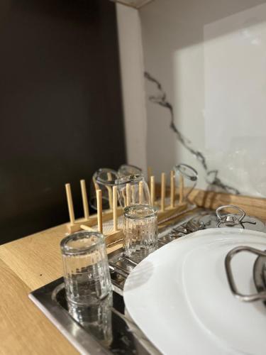 a row of glasses on a counter next to a sink at Studio Astir in Tirane