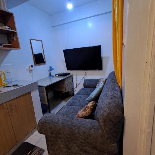 a living room with a couch and a television at SpeedwayHaven, 2Mins TO SpurMall & Ashaki Resort 1750kes in Ruiru